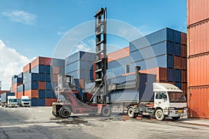 Forklift handling container box loading at docks with truck for