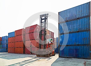 Forklift handling container box loading to truck in import export logistic zone.