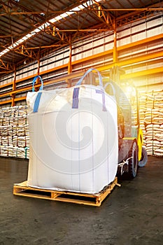 Forklift handling jumbo sugar bag for stuffing into container for export. Distribution, Logistics Import Export.