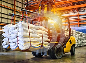 Forklift handling sugar bag for stuffing into container for export.