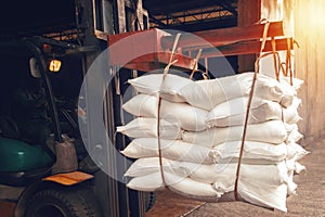 Forklift handling white sugar bag from warehouse for stuffing into container for export, vintage color