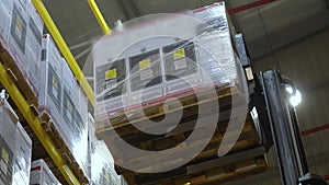 Forklift in a large modern warehouse, a forklift removes the box from the top shelf