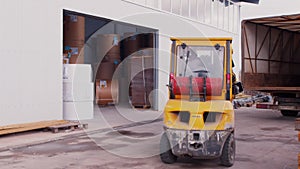 Forklift Loader Goes up Ramp To Load truck trailer equipment outdoors at warehouse. Closeup of wheel