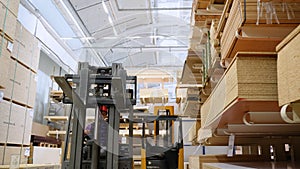 Forklift loader in storage lumber warehouse. Distribution products. Delivery. Logistics. Transportation