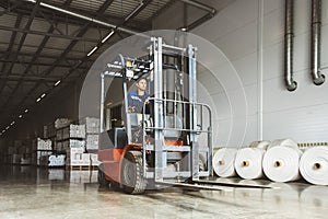 Forklift loader for warehouse works outdoors with risen forks