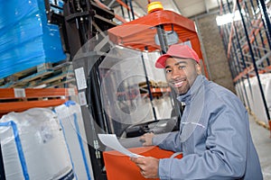 Forklift putting cargo from warehouse to truck outdoors