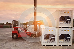 Forklift reach stacker is lifting reefer container in the  depot. photo