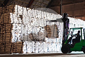 Forklift stacking up sugar bag inside warehouse, sugar warehouse operation. Agriculture product storing and logistics for import a