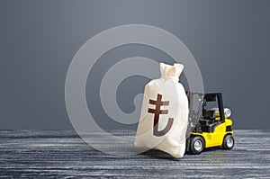 Forklift transports a turkish lira money bag. Attraction of large investments in business and economy, cheap loans, leasing.