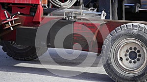 Forklift truck driver in a factory or warehouse driving between rows of shelving with stacks of boxes and packaging