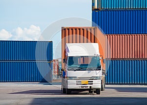 Forklift truck lifting cargo container in shipping yard or dock yard against sunrise sky for transportation import