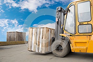 Forklift truck transporting wood cargo box photo