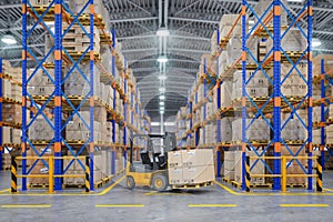 Forklift truck in warehouse or storage and shelves with cardboard boxes photo