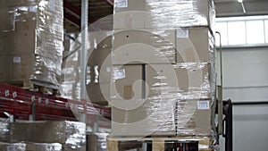 Forklift Trucks unload Pallets with Cardboard Boxes at modern warehouse