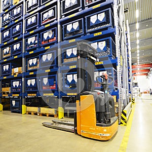 Forklift trucks in a warehouse in a factory with technical goods