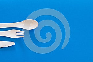 Forks Cutlery on a bright blue background. Eco-friendly wooden disposable cutlery on bright colored backdrop. Wallpapers for