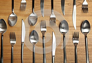 Forks, knives and spoons on wooden table