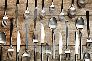 Forks, knives and spoons on wooden table