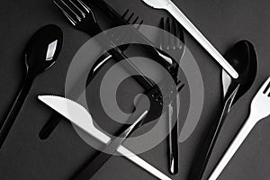 Forks and spoons on gray background. Plastic cutlery, ecology, environmental pollution by plastic, disposable tableware, waste