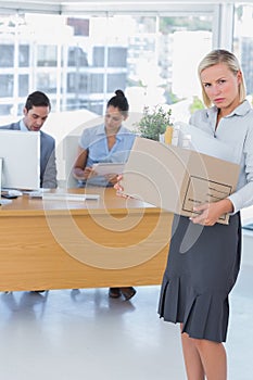Forlorn businesswoman leaving office after being let go photo