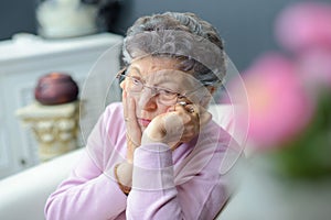 Forlorn elderly lady sitting alone photo