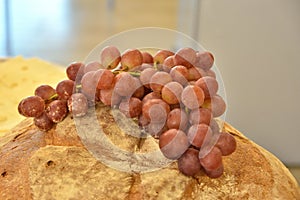 Form of homemade bread with a bunch of pink grapes,
