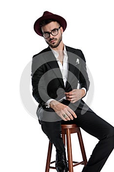 Formal business man sitting and opening jacket seductive