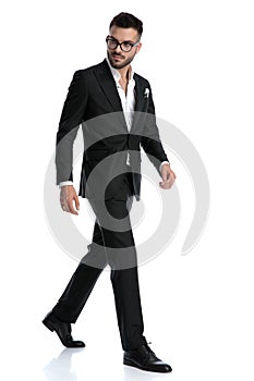 Formal business man walking one way while looking the other