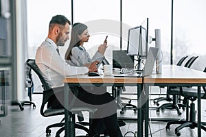 In formal clothes. Brokers doing research. Two employees are working in the office together