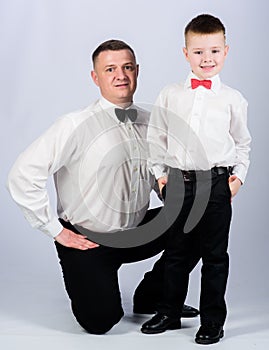 Formal event. Little son following fathers example of noble man. Gentleman upbringing. Father and son formal clothes