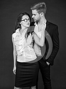 formal fashionable couple in love in business look on black background, colleague