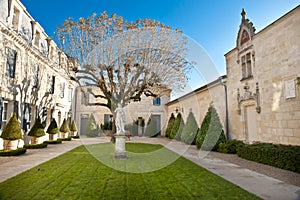 Garden of Chateau Haut Brion, Bordeaux France. Beautiful formal garden, courtyard with statue  on lawn