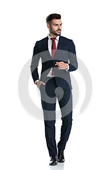 Formal guy walking with hand in pocket looking aside happy