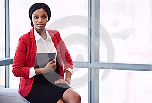 Formal portrait of black businesswoman holding a digital tablet