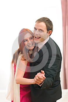 Formally dressed happy couple having fun dancing photo