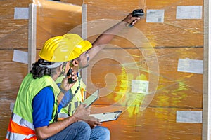 Forman worker scanning boxes in warehouse rack, Warehouse workers with bar code scanner checking inventory, Workers working in photo