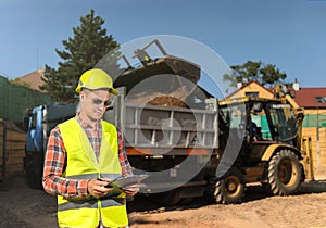 Forman young at the beginning of the construction work looking down the clipboard photo