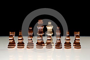 Formation of black chess pieces with a white queen