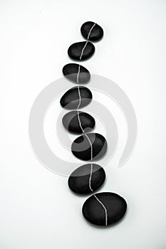 Formation of black stones imitating the vertebral column, isolated in white background photo