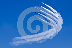 Formation of jet aircrafts turns as a team in blue sky.