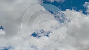 Formation and rapid movement of white clouds of different shapes in the blue sky in late spring at sunset.