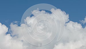 Formation and rapid movement of white clouds of different shapes in the blue sky in late spring at sunset.