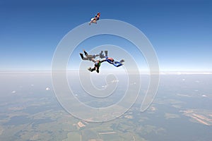 Formation skydiving. A group of skydivers are in the sky.