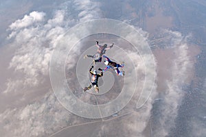 Formation skydiving. Three skydivers are in the sky.