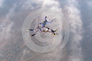 Formation skydiving. Three skydivers are in the sky.