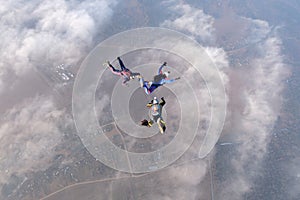 Formation skydiving. Three skydivers are in the sky.