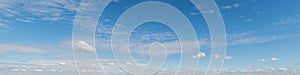 Formation of soft silver clouds float across blue sky, panorama format