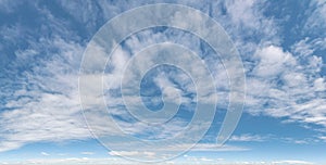Formation of soft silver clouds float across blue sky, panorama format