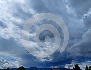 formidable sky with dark gray clouds over hills in Slovenia