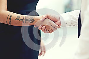 Forming a pact together. Closeup shot of businesspeople shaking hands in an office.